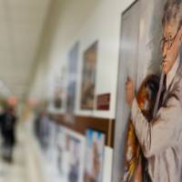 Close up of art work while people looking at gallery wall are out of focus in background